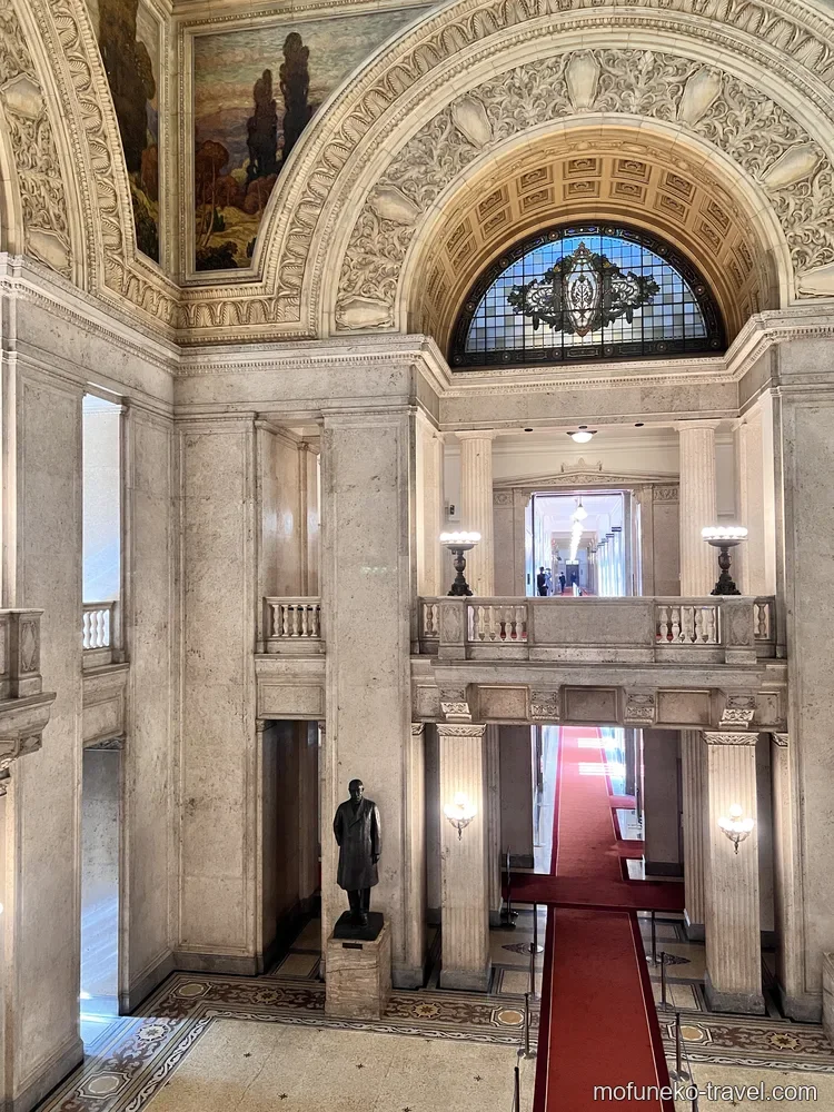 国会議事堂・中央広間の全体写真。伊藤博文の銅像と4階吹き抜けの壮大なスケール感。赤いカーペットが広間を彩る。