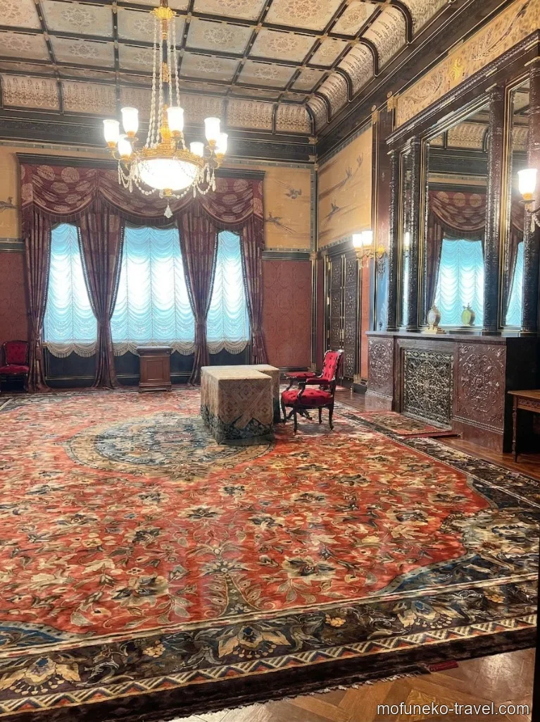 国会議事堂（衆議院）御休所。赤い絨毯と赤いベルベットの椅子、青いカーテンが印象的な別アングル。